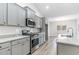 Modern kitchen with gray cabinetry, granite countertops, stainless steel appliances, and wood-look floors at 276 Stillbrook Dr., Longs, SC 29568