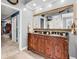 This bathroom features a dual sink vanity with a large mirror and a view into an adjacent room at 3026 Cedar Creek Run, Little River, SC 29566