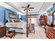 This is a main bedroom with blue walls and a four poster bed with a ceiling fan and two dressers at 3026 Cedar Creek Run, Little River, SC 29566