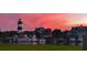 Picturesque waterfront scene with boats, a lighthouse, and homes at sunset at 3026 Cedar Creek Run, Little River, SC 29566