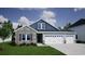 Charming two-story home featuring stone accents, a two-car garage, and a well-manicured front lawn at 309 Mayflower Dr., Calabash, NC 28467