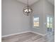 Minimalist dining room with wood floors, a modern chandelier, and sliding glass door to patio at 4028 Bucolic Loop, Myrtle Beach, SC 29588