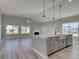 Open concept living area and kitchen featuring a fireplace and large windows for natural light at 4028 Bucolic Loop, Myrtle Beach, SC 29588