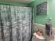 A serene bathroom with a seashell-themed shower curtain and calming green walls at 405 Cambridge Circle # B5, Murrells Inlet, SC 29576