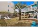 Expansive backyard with lush grass, lounge chairs, and a charming wooden deck perfect for outdoor relaxation at 409 25Th Ave. N, North Myrtle Beach, SC 29582