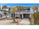 Charming raised beach house with palm trees, covered parking, and white picket fence at 409 25Th Ave. N, North Myrtle Beach, SC 29582