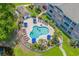 An aerial view of a community pool surrounded by residences, landscaping, and a small pond at 4173 Hibiscus Dr. # 204, Little River, SC 29566