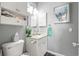 Bright bathroom featuring a vanity, wall cabinet, toilet, decorative art, and neutral color scheme at 4173 Hibiscus Dr. # 204, Little River, SC 29566