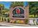 The Gardens at Cypress Bay brick community sign with vibrant floral accents at 4173 Hibiscus Dr. # 204, Little River, SC 29566