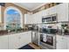 Well-equipped kitchen featuring stainless steel appliances, granite countertops, and white cabinets at 4173 Hibiscus Dr. # 204, Little River, SC 29566