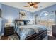 Airy main bedroom with an arched window, wood-look ceiling fan, and blue walls at 4173 Hibiscus Dr. # 204, Little River, SC 29566