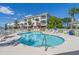 Community swimming pool with ample lounge chairs and tables surrounded by lush landscaping at 4173 Hibiscus Dr. # 204, Little River, SC 29566