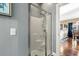 Modern glass enclosed shower with chrome fixtures, shelving and a view into adjacent room at 4173 Hibiscus Dr. # 204, Little River, SC 29566