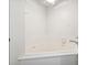 Bathroom corner soaking tub with white tiled surround and white fixtures for relaxation at 4396 Baldwin Ave. # 138, Little River, SC 29566