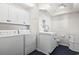 Well-organized laundry room boasts a washer, dryer, sink, and storage, blending functionality and a modern aesthetic at 4396 Baldwin Ave. # 138, Little River, SC 29566