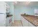 Kitchen with white cabinets, granite counters and white appliances in this bright open floor plan at 4445 Kingsport Rd. # 406, Little River, SC 29566