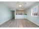 Open-concept living space with laminate flooring, seafoam walls, and a bar overlooking the kitchen at 4445 Kingsport Rd. # 406, Little River, SC 29566