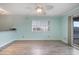 Sunlit open living area with laminate flooring, seafoam walls, and slider to balcony overlooking water at 4445 Kingsport Rd. # 406, Little River, SC 29566