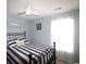 Cozy bedroom with natural light, featuring a striped comforter, ceiling fan, and beach-themed wall art at 449 Pennington Loop, Myrtle Beach, SC 29588