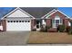 Charming single-story home features a brick facade, attached garage, and well-maintained front yard at 449 Pennington Loop, Myrtle Beach, SC 29588