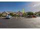 A well-maintained condo complex with ample parking and mature landscaping on a clear day at 4545 Lighthouse Dr. # 28C, Little River, SC 29566
