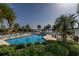 Outdoor community pool with inviting lounge chairs surrounded by palm trees and well-manicured landscaping at 4545 Lighthouse Dr. # 28C, Little River, SC 29566
