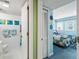 View of bathroom with commode, plus a bedroom featuring bright blue walls, two twin beds, and nautical decor at 5905 South Kings Hwy. # 4219-D, Myrtle Beach, SC 29575