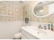Neat bathroom featuring a white vanity, toilet, and an oval mirror with elegant wallpaper accents at 5905 South Kings Hwy. # 4107-D, Myrtle Beach, SC 29575