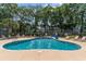Community outdoor swimming pool surrounded by lounge chairs and lush trees at 5905 South Kings Hwy. # 4107-D, Myrtle Beach, SC 29575