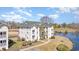 Scenic view of a multi-story building, surrounded by lush greenery and a serene pond at 597 Blue River Ct. # H2, Myrtle Beach, SC 29579