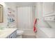 Functional bathroom with a shower-tub combo, storage shelves, and a convenient washer/dryer at 597 Blue River Ct. # H2, Myrtle Beach, SC 29579