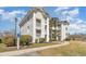 Well-maintained white condo complex featuring multiple stories, balconies and verdant landscaping at 597 Blue River Ct. # H2, Myrtle Beach, SC 29579