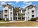 Beautiful white condo building featuring multiple stories and balconies with tropical landscaping at 597 Blue River Ct. # H2, Myrtle Beach, SC 29579