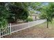 Backyard featuring a white picket fence and mature trees, offering privacy and a natural setting at 6006 Quinn Rd., Myrtle Beach, SC 29579