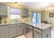 Stylish kitchen featuring gray cabinets, granite countertops, stainless steel appliances, and a view to the patio at 6006 Quinn Rd., Myrtle Beach, SC 29579