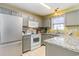 Traditional kitchen featuring gray cabinets, white appliances, and light granite countertops at 6006 Quinn Rd., Myrtle Beach, SC 29579