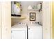 A well-lit laundry room with a washing machine, dryer, water heater and storage shelves for convenience at 6006 Quinn Rd., Myrtle Beach, SC 29579