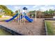 Community playground featuring slides, climbing bars, and swings near a pond with fountain at 6006 Quinn Rd., Myrtle Beach, SC 29579