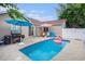 Backyard pool with an umbrella, lounge chairs, and lush landscaping for outdoor relaxation at 6006 Quinn Rd., Myrtle Beach, SC 29579