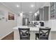 A modern kitchen featuring gray cabinets, stainless steel appliances, a white tile backsplash, and quartz countertops at 6069 Tramonto St., Myrtle Beach, SC 29572
