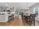 Open-concept kitchen, dining, and living area with wood floors, stainless steel appliances, and access to a screened porch at 6069 Tramonto St., Myrtle Beach, SC 29572