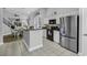 Open-concept kitchen featuring an island, stainless appliances, and views into the dining area and staircase at 6203 Catalina Dr. # 2316, North Myrtle Beach, SC 29582