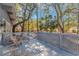 A serene back deck shaded by mature trees features wood furniture for relaxation at 67 Massick Ln., Pawleys Island, SC 29585