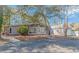 Inviting home featuring stone accents, a covered porch, and a well-maintained gravel driveway surrounded by mature trees at 67 Massick Ln., Pawleys Island, SC 29585