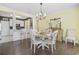 Bright dining room boasts modern chandelier, hardwood floors, and views into the open kitchen at 730 Pickering Dr. # 201, Murrells Inlet, SC 29576