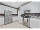 Modern kitchen with stainless steel appliances, white cabinets, and tile flooring at 730 Pickering Dr. # 201, Murrells Inlet, SC 29576