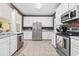 Bright kitchen with stainless steel appliances, white cabinets, and tile flooring at 730 Pickering Dr. # 201, Murrells Inlet, SC 29576