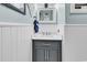 Modern bathroom with white wainscoting, grey vanity, and bright lighting at 7714 Woodland Dr., Myrtle Beach, SC 29572
