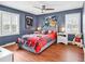 Inviting bedroom with hardwood floors, ceiling fan, and sports-themed decorations at 7714 Woodland Dr., Myrtle Beach, SC 29572