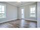 Bright bedroom with wood floors, two large windows, and a patio door at 8053 Laurel Ash Ave., Myrtle Beach, SC 29572